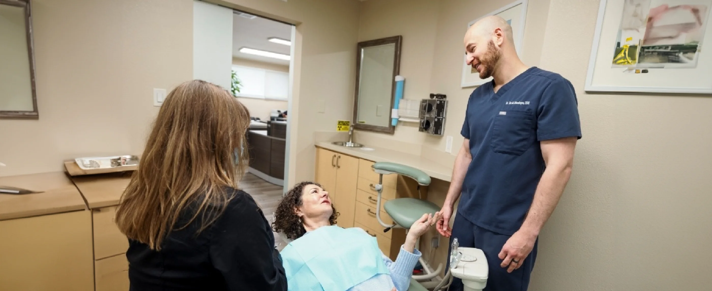 Dentist smiling at patient leaning back in dental chair