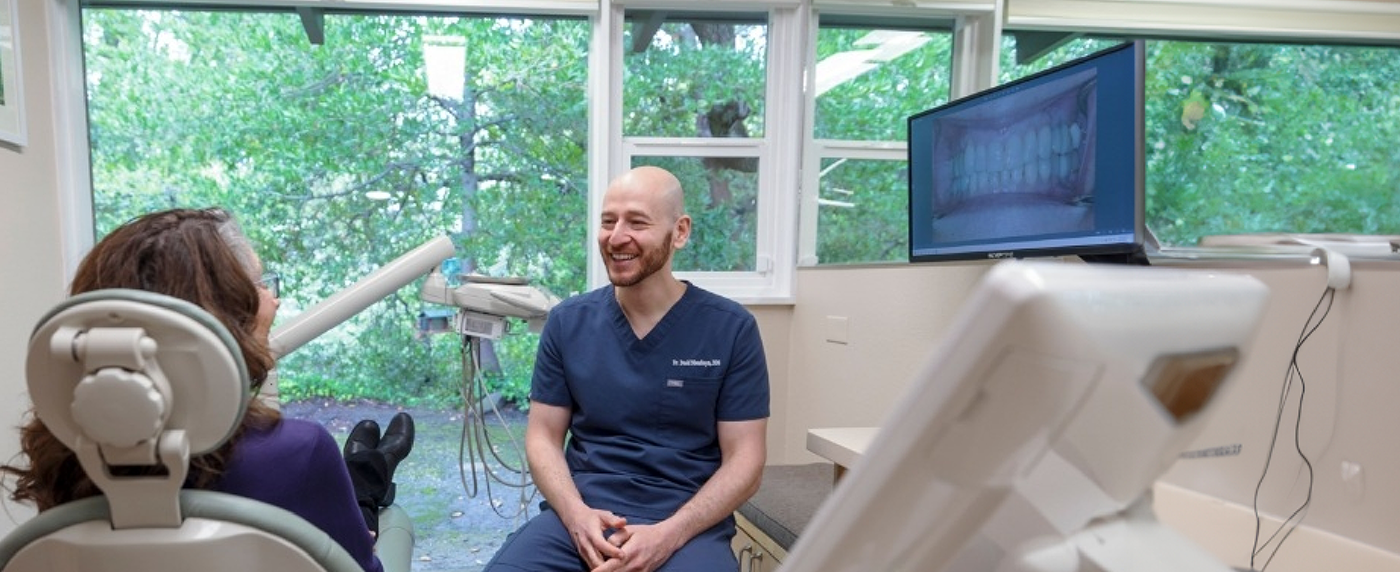 Laughing dentist talking to patient