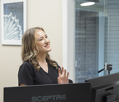Dental team member smiling and waving