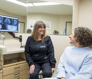 Dental team member smiling at a patient in the treatment chair