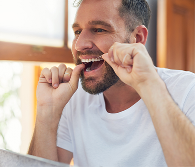 Man flossing his teeth