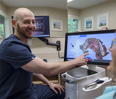 Doctor David showing a patient a scan of their teeth