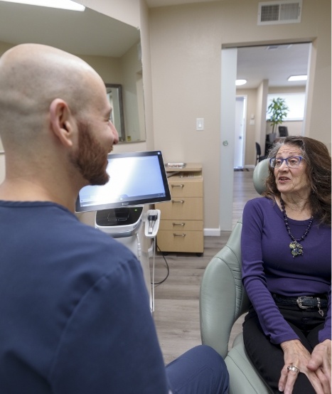 Dentist talking to seated female patient