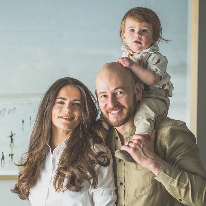 Doctor David Nisenboym smiling with his wife and child