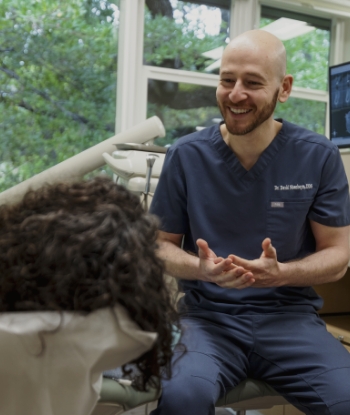 Doctor David smiling while talking to a dental patient