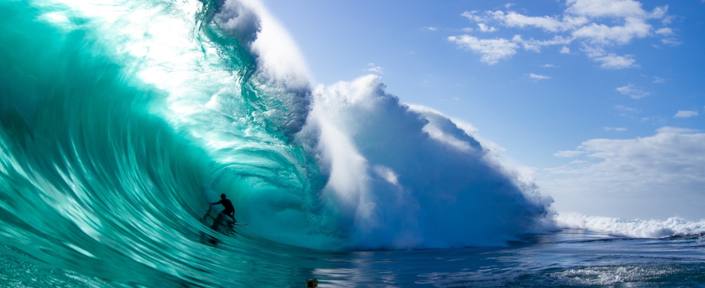 Person surfing on a big blue wave