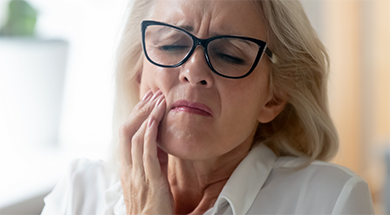 Woman holding the side of her face in pain