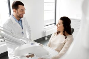 Dentist and patient having friendly conversation during dental implant consultation