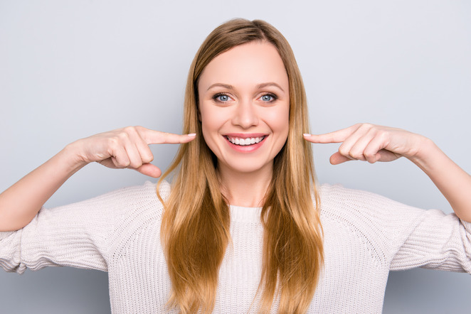 woman pointing to smile after cosmetic dentistry 