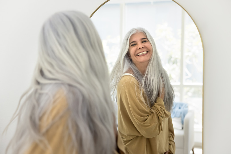 Patient smiling in the mirror after cosmetic dentistry