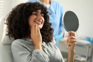 Dental patient smiling at herself in mirror